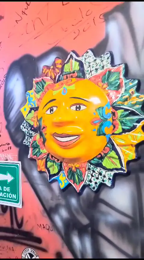 Mural de un sol de colores pintado en la pared del gimnasio