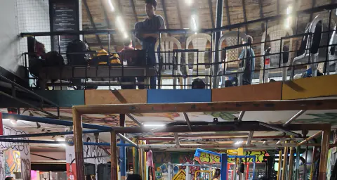 Segundo piso del gimnasio con máquinas y barandas